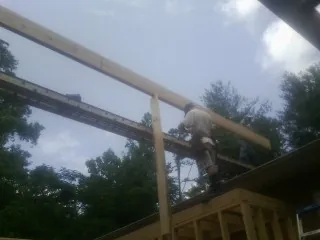 Carpenter setting a ridge beam over a new addition frame — Ice Dam Removal by Roofing Brothers in Croton On Hudson