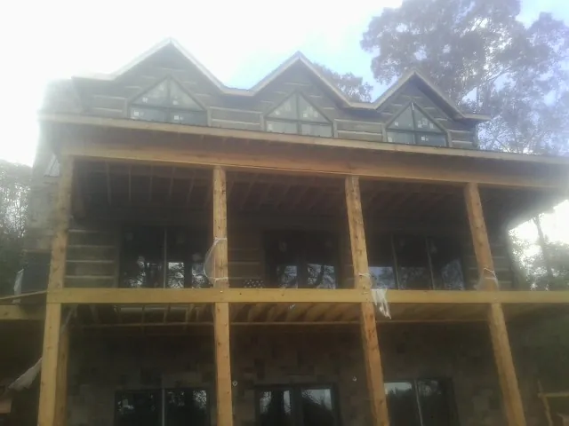 Dormers and porch framing on a large log home under construction — Roof Coating work by our crew in Croton On Hudson