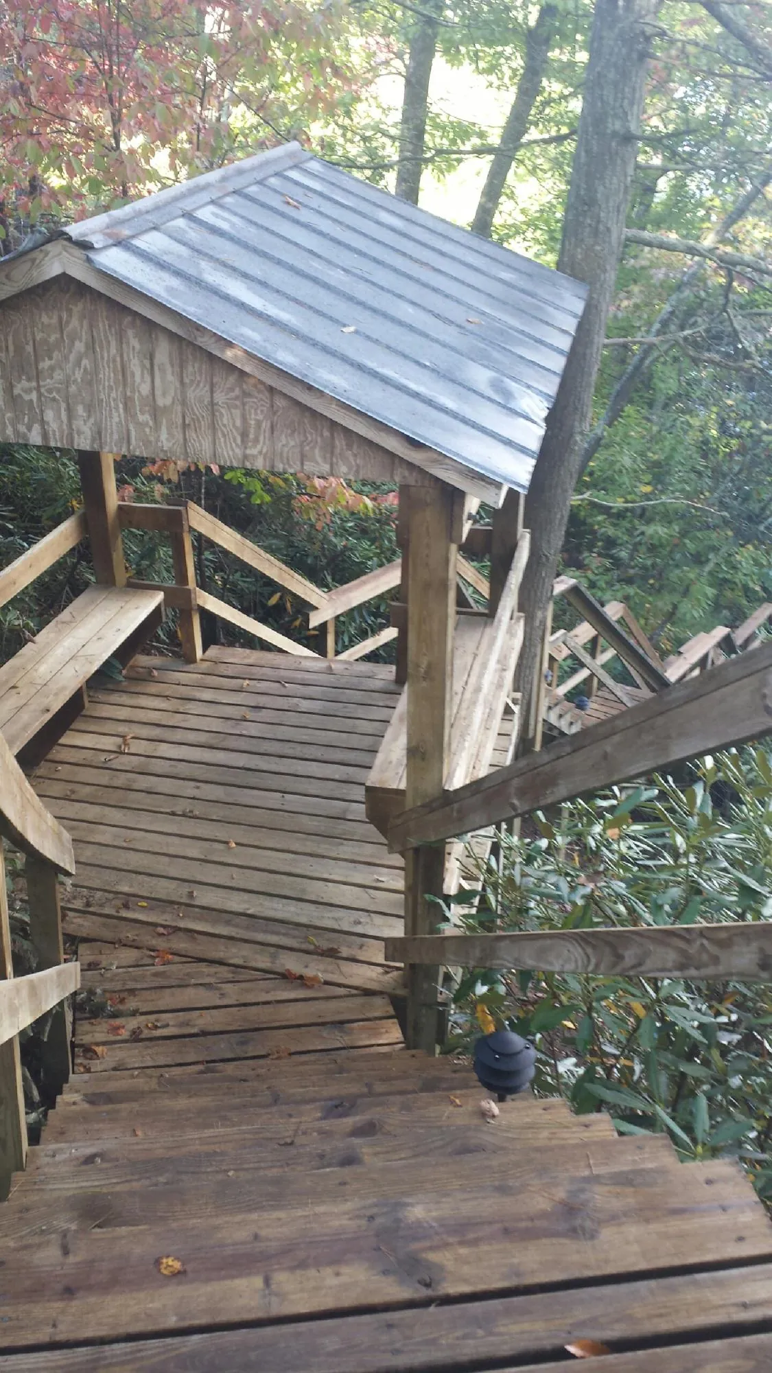 Metal roofed shelter over wooden steps on a wooded walkway — Skylight Repair & Installation work by our crew in Croton On Hudson
