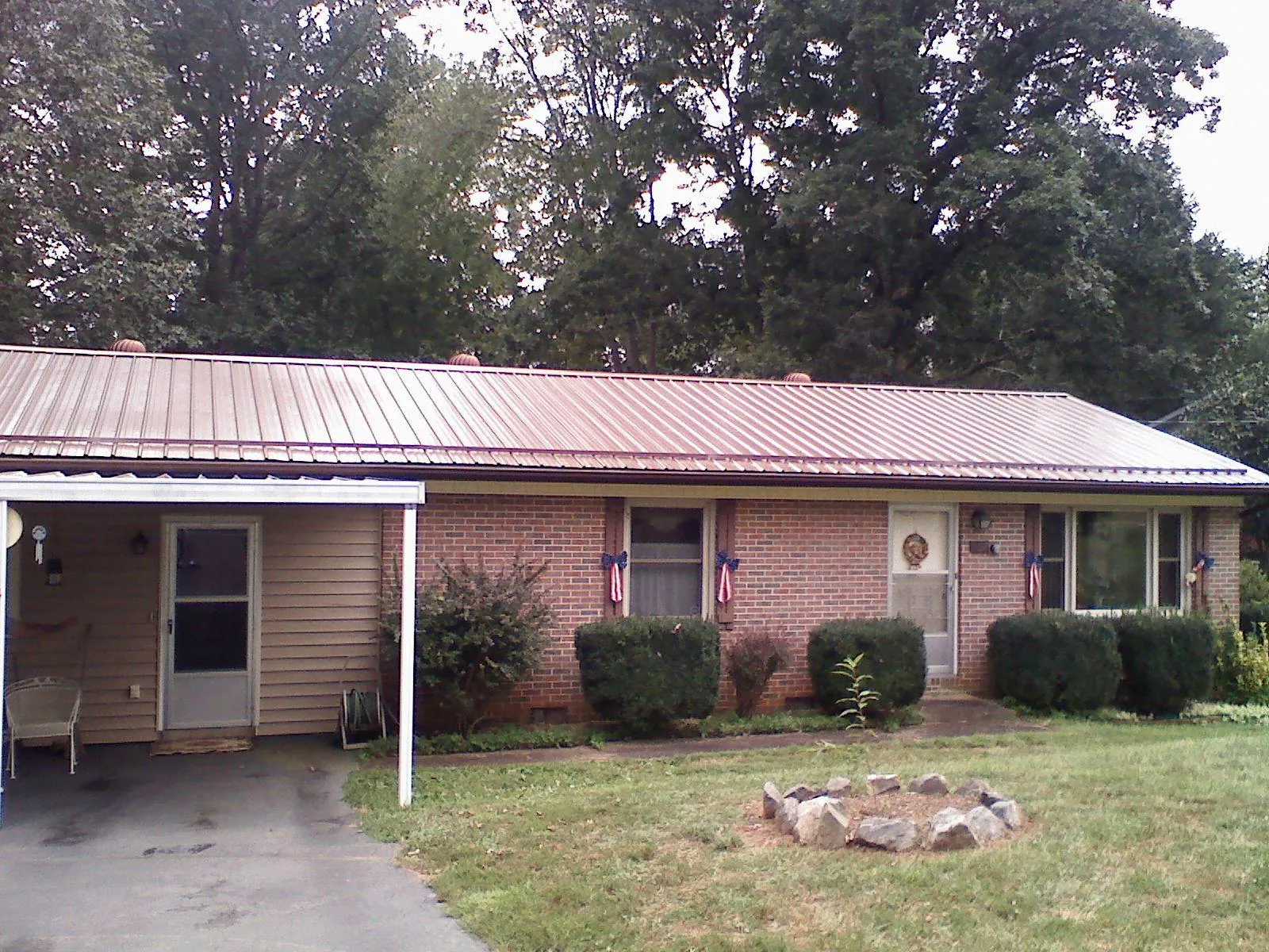 Bronze metal roof and carport on a brick ranch home — Roof Repair work by our crew in Croton On Hudson